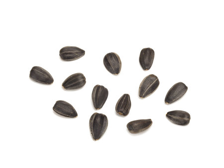 fried black sunflower seeds unpeeled, close-up on white background