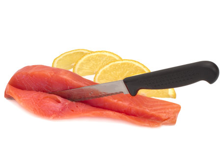 slice of salted salmon on white background with knife and slices of lemon