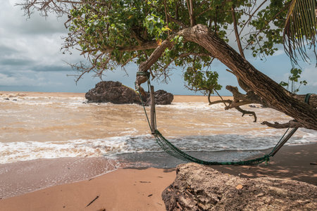 An abandoned hammock on an empty beach in Axim Ghana West Africa.