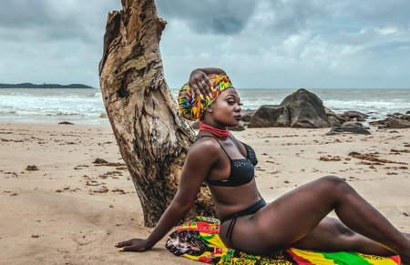 Ghana woman with a colorful blanket and headdress on a beach in Ghana West Africaの写真素材