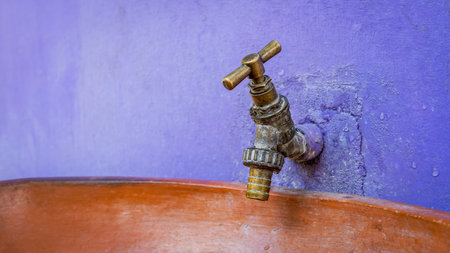 Water tap that sits on a colorful wall in a small African village in Keta where water is used...