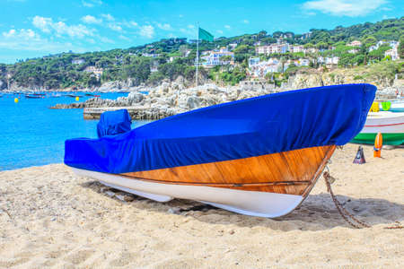 Fishing boat covered with a blanket on the beachの写真素材