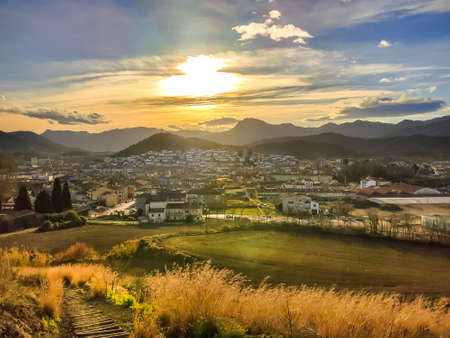 Beautiful Sunset over a small town surrounded by mountains.の写真素材