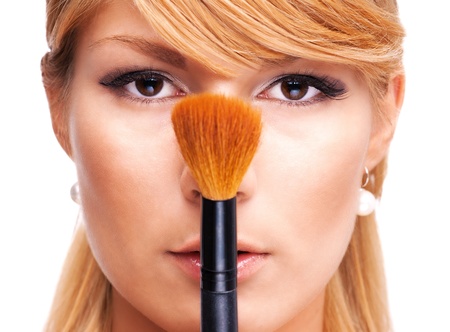 Beautiful blond girl with make-up brushの写真素材