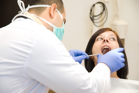 the dentist is looking at the patientの写真素材