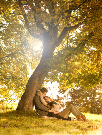 Passionate love in the park under a treeの写真素材