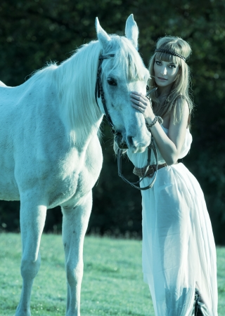 Portrait of a white horse and womanの写真素材