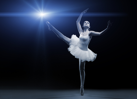 Ballet dancer in white tutu posing on one legの写真素材