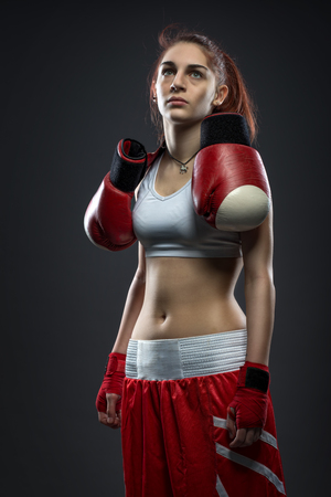 Boxing woman standing in dress boxing , boxing gloves on his shoulderの写真素材