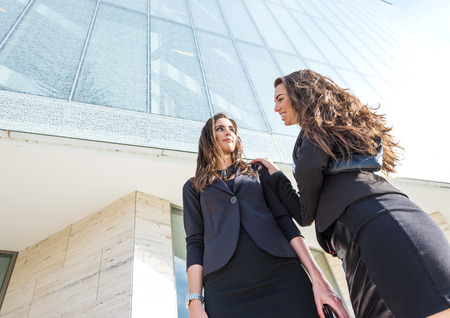 Two  pretty businesswoman in front of a trade buildingの写真素材