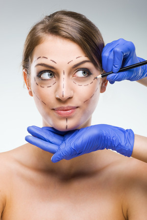 Beautiful woman with plastic surgery, depiction, plastic surgeon handsの写真素材
