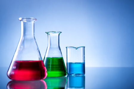Laboratory equipment, bottles, flasks with color liquid  on blue backgroundの写真素材