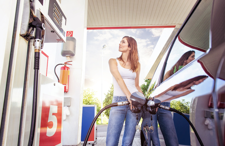 Pretty young woman refuel the carの写真素材