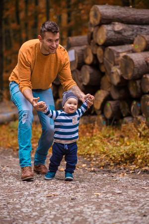 A young father walks in the woods with a little boyの写真素材