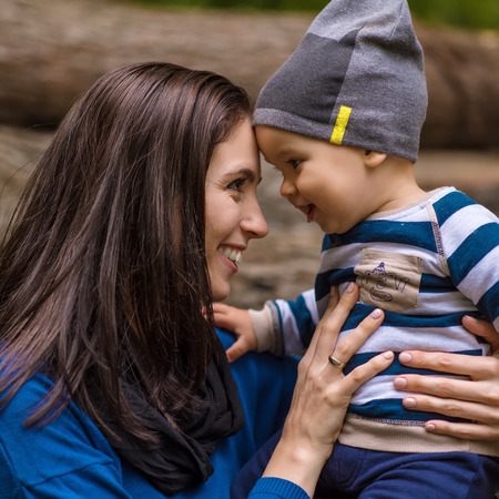 Beautiful young mother with her son in the forestの写真素材