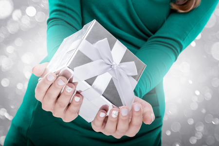 Woman holding a gift box. Close-up shotの写真素材