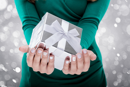 Woman holding a gift box. Close-up shotの写真素材