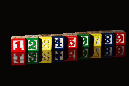 Wooden cubes and numbers isolated on black background