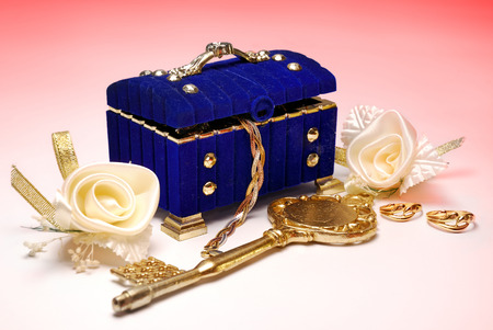 Treasure coffin. Golden key, wedding rings and white roses isolatedの写真素材