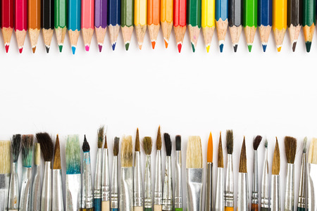 Abstract background from paintbrushes and color pencils on whiteの写真素材