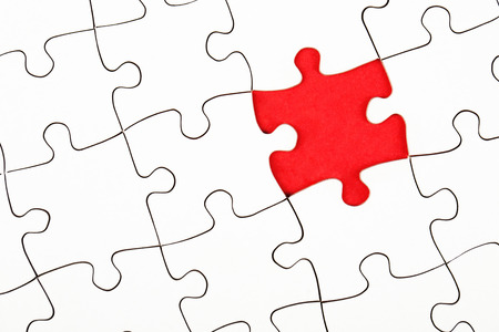 Missing piece in a puzzle on red background, business conceptionの写真素材