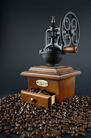 Retro coffee grinder and coffee beans isolated on black backgroundの写真素材