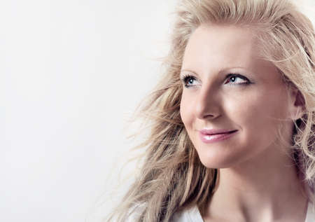 Portrait of Young beautiful Caucasian blond woman on a white backgroundの写真素材