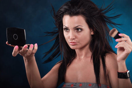 Attractive young woman putting some make-upの写真素材