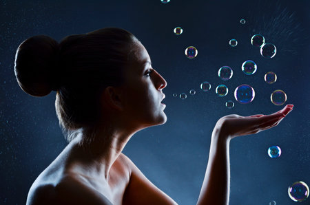 Beautiful woman playing with bubblesの写真素材