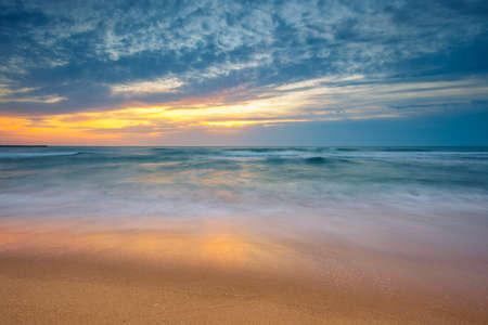 Beach sunrise over the sea and dramatic seaの写真素材