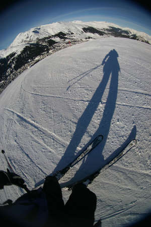 Skiing at its best. Fisheye shot taken in the middle of the slope, showing skier, slope, and vista.の写真素材