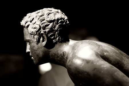 A roman bronze statue of a boy. The expression of youth can be 2000 years old and still appear young...の写真素材