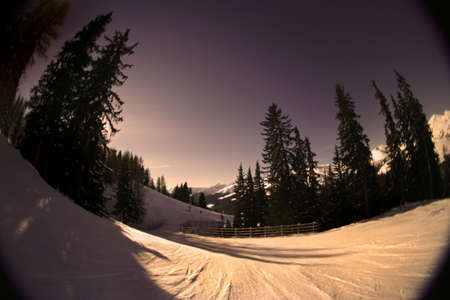 Fisheye shot of a skiing slope in the alps. Warm tones are intentional to create mood.の写真素材