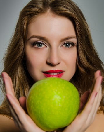 Woman with green apple in hands, studioの写真素材