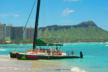 Waikiki, HI, USA - July 23, 2019: The Maita'i Catamaran is leaving the beach.のeditorial素材