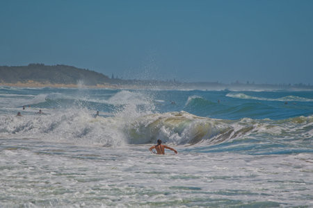 Dicky Beach, Qld, Australia - February 21,2021: People enjoying waves in the ocean on a hot day,  Sunshine Coast Australiaのeditorial素材