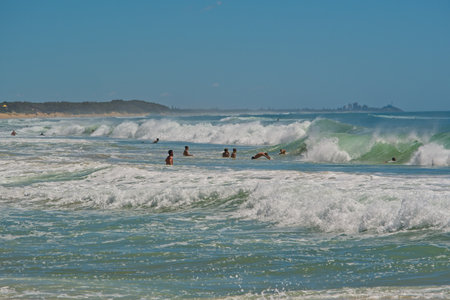 Dicky Beach, Qld, Australia - February 21,2021: People enjoying waves in the ocean on a hot day,  Sunshine Coast Australiaのeditorial素材