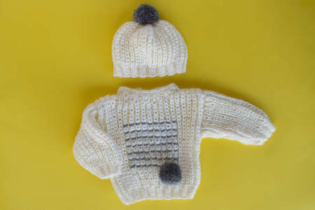 Knitted baby sweater and matching hat with pompomの写真素材