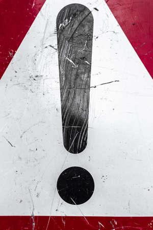 Extreme close-up of a warning sign with scratches and signs of wear.の写真素材