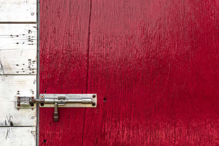 Front view of a latch installed on an old wooden door.の写真素材