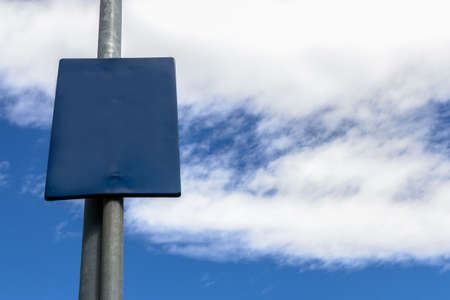 A blank sign with blue sky and clouds in the background.の写真素材