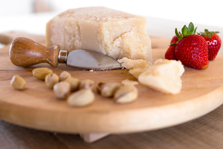 Chopping board with cheese, pistachios and strawberries.の写真素材