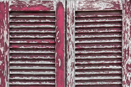 An old window closed with peeling paint and rotten wood.の写真素材