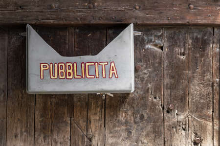 Old box advertising nailed on a wooden door.の写真素材