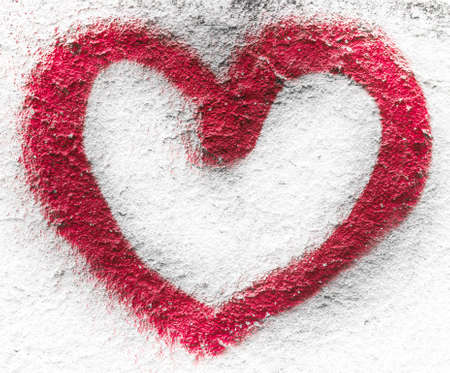 The profile of a red heart, drawn on a wall with spray.の写真素材