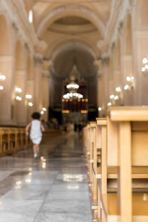 A little girl runs in the nave of a church, to the altar.の写真素材