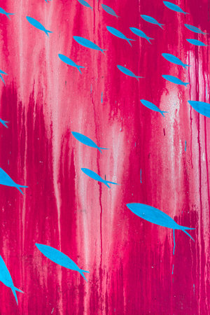 Pattern of blue fish painted on a vaertical panel of color fuchsia.の写真素材