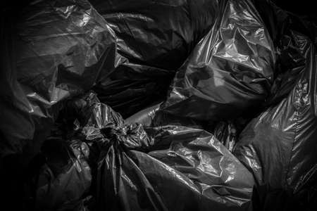 A pile of garbage bags blacks, abandoned on the street.の写真素材