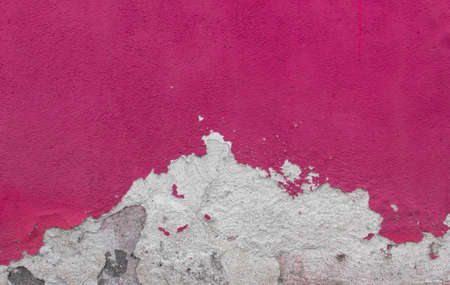 Cracked and textured pink wall, plaster backgroundの写真素材