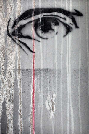 Eye with rivers of tears of acid and blood colorful graffiti on city wall.の写真素材